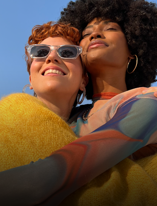 A vibrant photograph of two people embracing, demonstrating the Pro-level camera capabilities of iPhone 14.